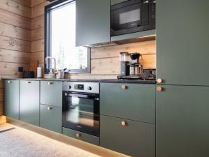a kitchen with stainless steel appliances and a window at Holiday Home Villa pirunpelto by Interhome in Kuopio