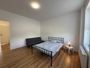 a bedroom with a bed and a lamp on a wooden floor at Modern apartments for employees and families in Altenburg in Altenburg
