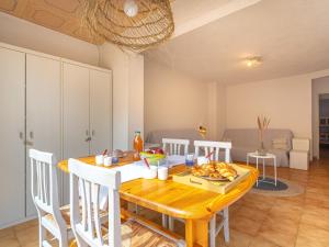 Il comprend une cuisine et une salle à manger avec une table et des chaises en bois. dans l'établissement Apartment Helios by Interhome, à Six-Fours-les-Plages