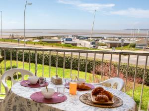 a table with bread and pastries on a balcony at Apartment Le Bellevue by Interhome in Saint-Brevin-les-Pins