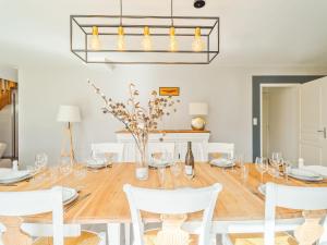 un comedor con una gran mesa de madera con sillas blancas en Holiday Home Villa des neuf plages by Interhome en Le Vau Piard