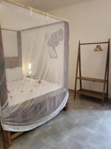 a bedroom with a bed covered in mosquito net at Babalao Bungalows in Nungwi