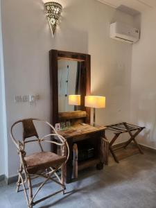 a room with a desk with a chair and a mirror at Babalao Bungalows in Nungwi