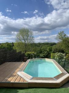 - une piscine avec une terrasse en bois à côté dans l'établissement Gite Oranis, maison de charme au cœur du Quercy blanc!, à Monjoi
