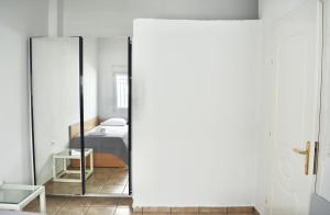 ペフコホリにあるN&J Apartment 3 by Booking Kottasの鏡付きのベッドルーム1室、ベッド1台が備わるベッドルーム1室を提供しています。