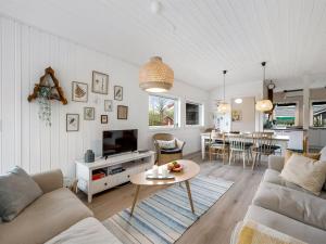 een woonkamer met een bank en een tafel bij Holiday Home Blakke - all inclusive - 850m to the inlet by Interhome in Hemmet
