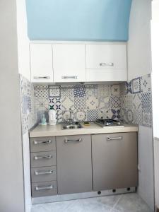 uma pequena cozinha com armários brancos e um lavatório em Studio with terrace at Formicola em Formicola