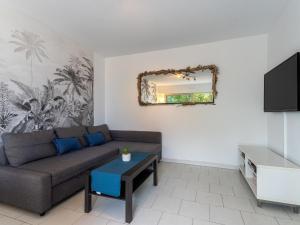 a living room with a couch and a mirror at Apartment Le Grand Large-2 by Interhome in Hyères