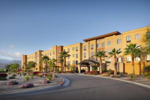 uma rua vazia em frente a um edifício com palmeiras em Homewood Suites by Hilton Cathedral City Palm Springs em Cathedral City