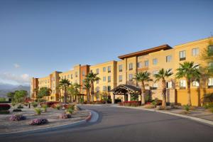 an empty street in front of a building with palm trees at Homewood Suites by Hilton Cathedral City Palm Springs in Cathedral City