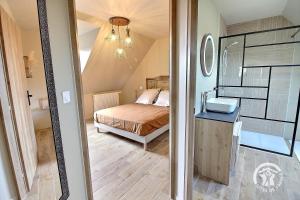 a small bedroom with a bed and a mirror at Le petit duc in Langast