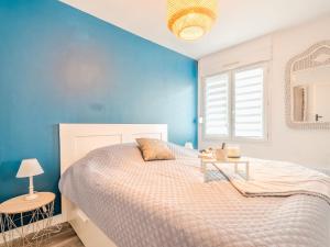 1 dormitorio con cama y pared azul en Apartment Le Manon by Interhome, en Dinard