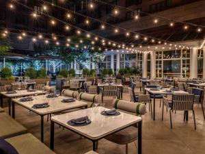 um restaurante com mesas, cadeiras e luzes em The Fairmont Washington DC em Washington