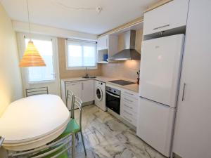 una pequeña cocina con nevera blanca y mesa en Apartment Playa Tarraco-2 by Interhome en Tarragona
