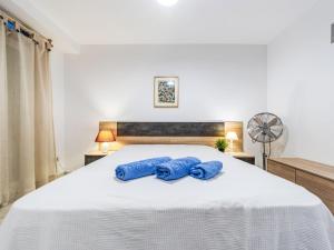 dwa niebieskie ręczniki na białym łóżku w sypialni w obiekcie Apartment Playa Tarraco-2 by Interhome w mieście Tarragona
