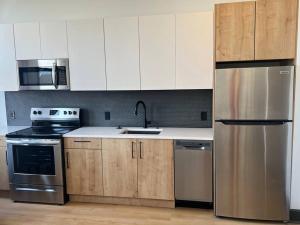 a kitchen with white cabinets and a stainless steel refrigerator at Urban Luxe Studio in Birmingham