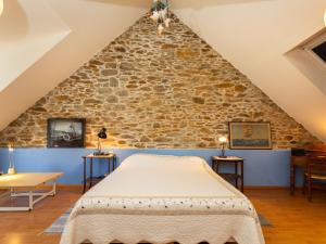 Ce lit se trouve dans un dortoir doté d'un mur en pierre. dans l'établissement Holiday Home Ville Guerin by Interhome, à Saint-Coulomb