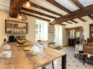 Il comprend une cuisine et un salon avec une table en bois. dans l'établissement Holiday Home Ville Guerin by Interhome, à Saint-Coulomb