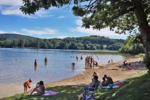 a group of people on the beach at a lake at Maison de charme Hautpoul in Mazamet +5 photos