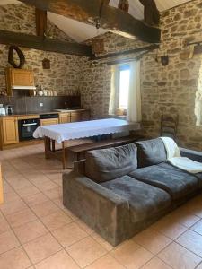 a living room with a couch and a stone wall at Maison de charme Hautpoul in Mazamet