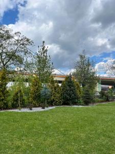 a green yard with trees in front of a building at AtmosferA in Bydgoszcz