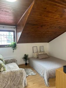 Chata Jana Dedinky في ديدينكي: غرفة نوم بسرير وسقف خشبي