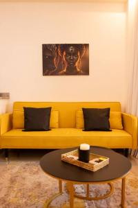 żółtą kanapę w salonie ze stołem w obiekcie Spacious studio by Luanda Bay with balcony w mieście Luanda