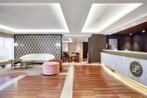 un vestíbulo de un hotel con mesa y sillas en Exe Mitre, en Barcelona