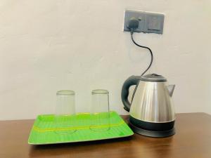 un bollitore per il tè e due bicchieri su un tavolo di Crocotopond ad Arugam
