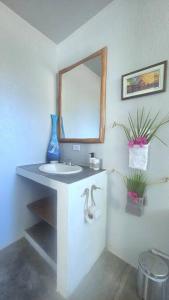 La salle de bains blanche est pourvue d'un lavabo et d'un miroir. dans l'établissement Villa Ballena Art Project, à La Cruz
