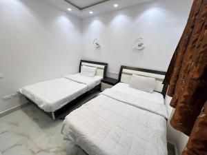 Duas camas num quarto com paredes brancas em Private Chalet in Porto Sokhna Pyramids em Ain Sokhna