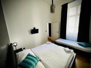 Top Wenceslas Square Apartment في براغ: غرفة نوم صغيرة بسريرين ونافذة