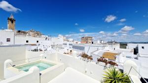 - Balcón con bañera de hidromasaje en la parte superior de un edificio en EntreArcos Casa Eco-Boutique en Vejer de la Frontera