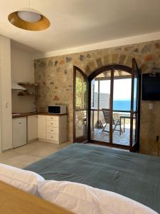 a bedroom with a bed and a view of the ocean at Papanestoras Apartments in Kardamili