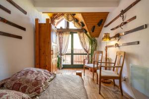 1 dormitorio con 1 cama, mesa y sillas en Fortuna Eco - Boutique Hotel en Băile Tuşnad