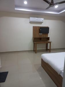 a bedroom with a bed and a tv on a table at HOTEL TIRATH in Rishīkesh