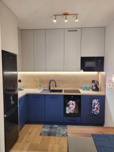 a kitchen with blue cabinets and a sink at Widokówka in Piła