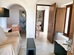 een woonkamer met een bank en een tafel bij Studio with sea view and furnished garden at Pantelleria 1 km away from the beach in Tracino