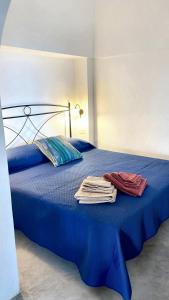 een blauw bed met handdoeken erop bij Studio with sea view and furnished garden at Pantelleria 1 km away from the beach in Tracino