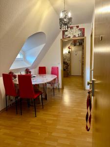 a dining room with a table and red chairs at Ferienzimmer Healing und Montuerwohnung in Weißenfels
