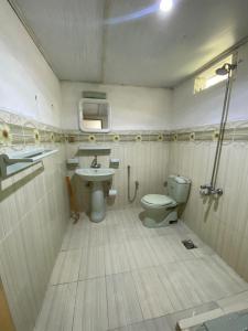 a small bathroom with a toilet and a sink at Rainbow Resort Kachura in Karachi