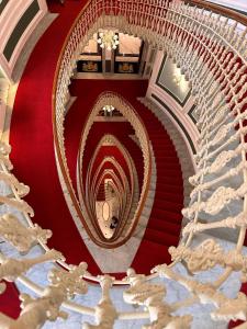 un escalier en colimaçon dans un bâtiment avec un sol rouge dans l'établissement Hotel Bristol Palace, à Gênes