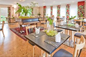 a restaurant with tables and chairs and a piano at Aspire Kronprinz, Trademark Collection by Wyndham in Schwäbisch Hall