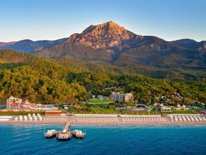 Movenpick Resort Antalya Tekirova في تيكيروفا: جزيرة في الماء مع جبال في الخلف