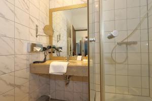 a bathroom with a sink and a mirror at DEVIN Art Hotel in Düsseldorf