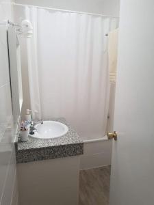 イスラ・デル・モラルにあるCasa en Punta Del Moralのバスルーム(シンク、白いシャワーカーテン付)