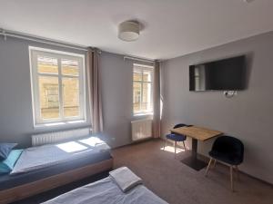 a bedroom with a bed and a desk and a tv at Bemma Apart Hostel in Wrocław