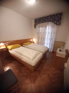 um quarto com 2 camas e uma janela em Hotel Dolomiti Saone em Tione di Trento