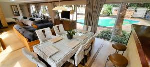 a living room with a table and chairs and a pool at Joy Haven - Open Plan Studio in Centurion