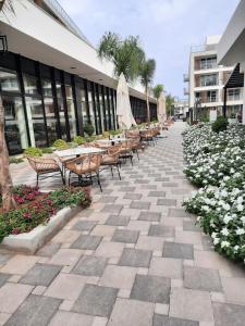 um pátio com mesas e cadeiras e flores em frente a um edifício em Courtyard 1+1 a1-34 em Trikomo